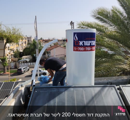 אדם מתקין דוד שמש על גג עם צינורות